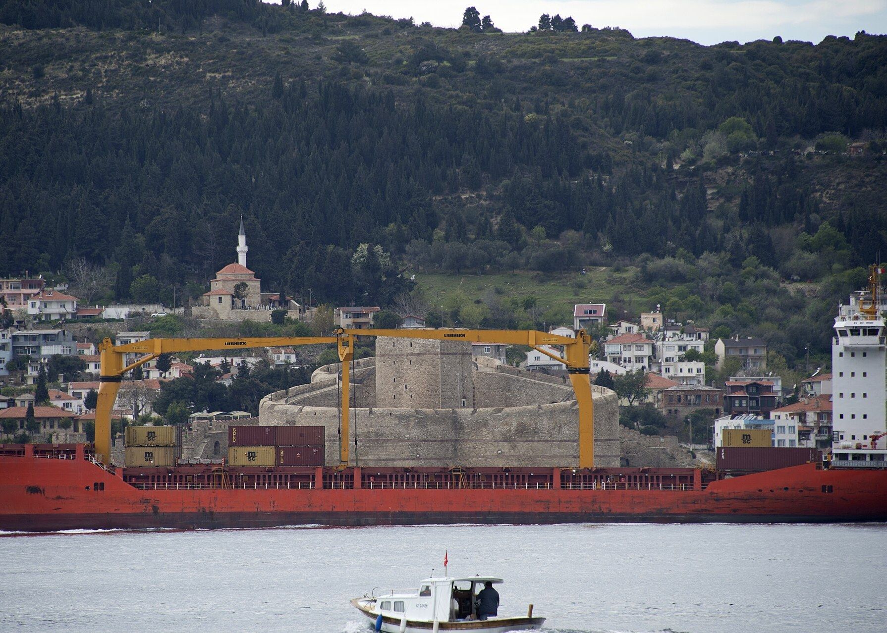 Çanakkale Boğazı'nda Kilitbahir Kalesi önünden geçen yük gemisi ve küçük bir tekne